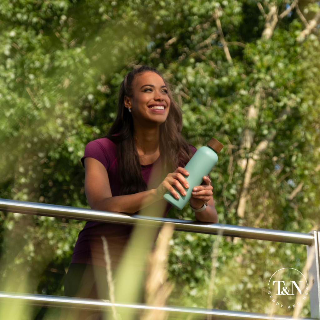 TrendyandNew Frau in Natur mit Flasche